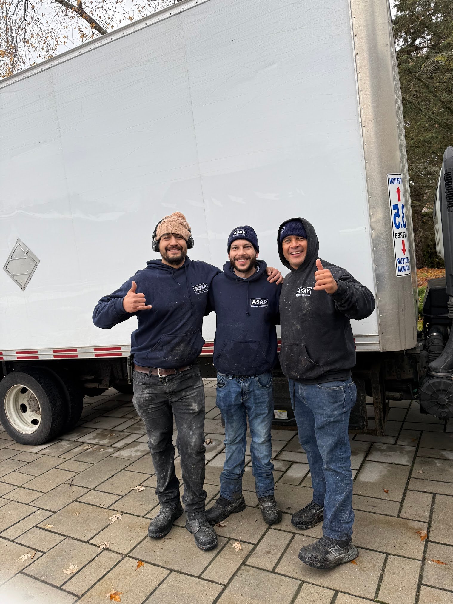 Three ASAP Junk Removal crew members in front of their truck