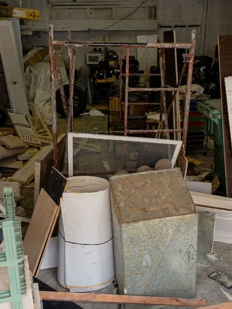 Basement and garage packed with scaffolding, old materials and debris