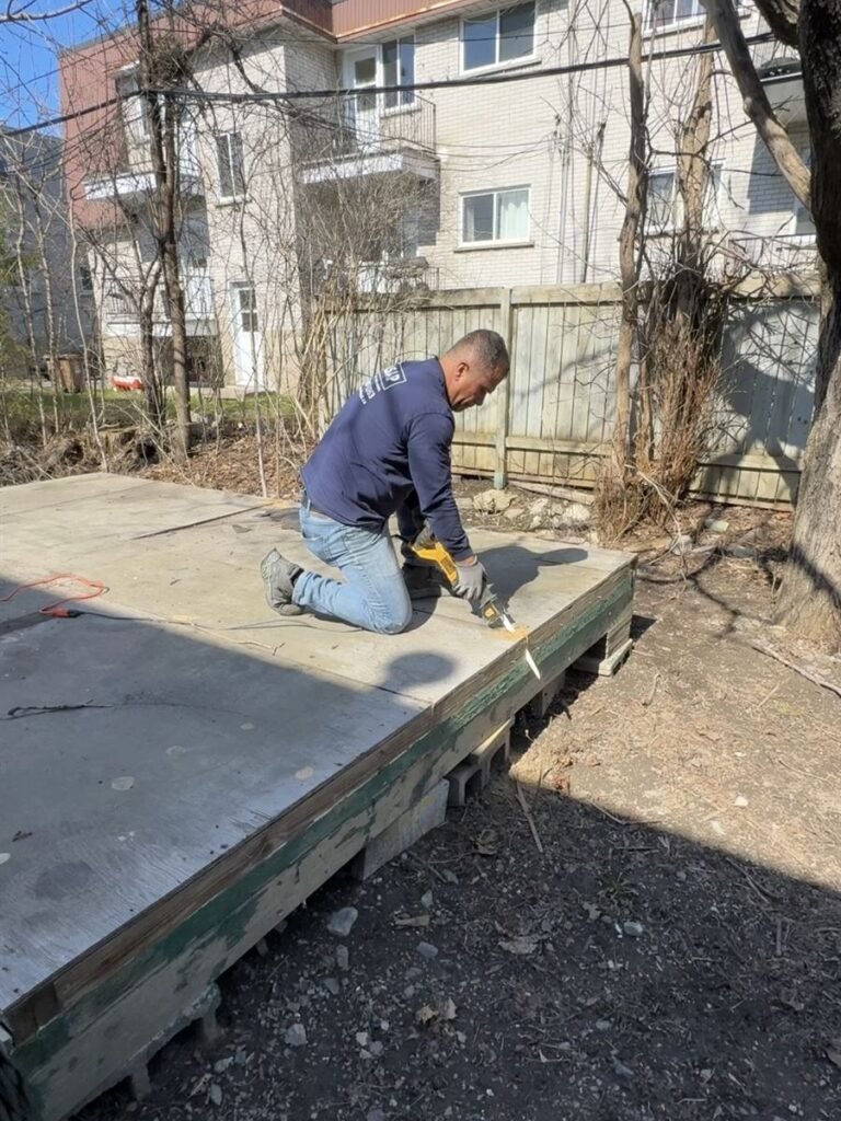 Crew member cutting up an old backyard platform for removal