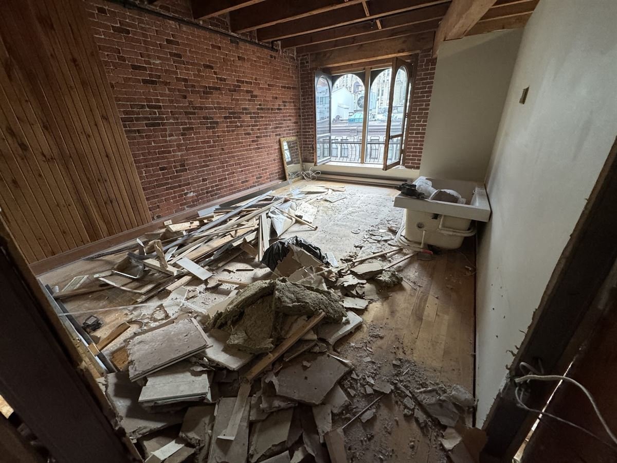 Water-damaged flooring and drywall torn out of a room