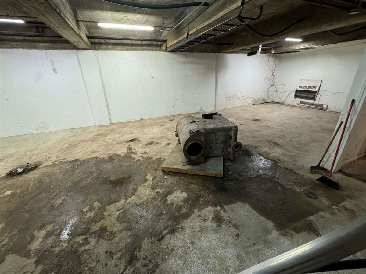 Basement floor after water-damaged items were cleared out