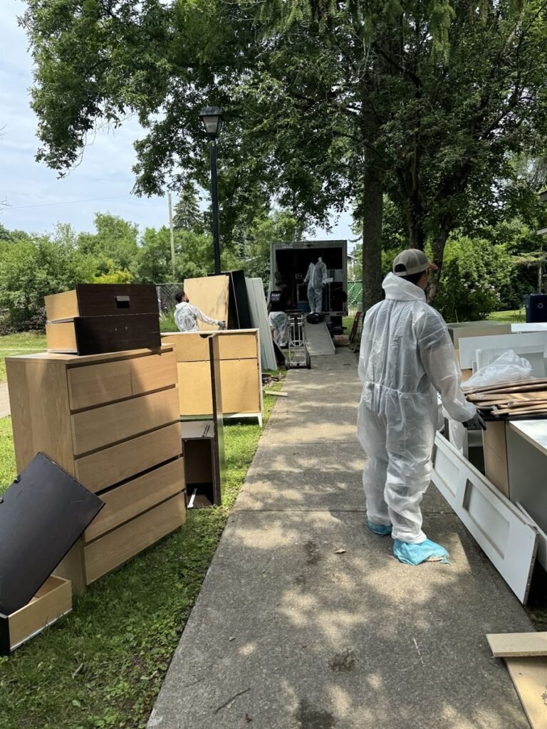 Crew member in a protective suit moving items out to the truck