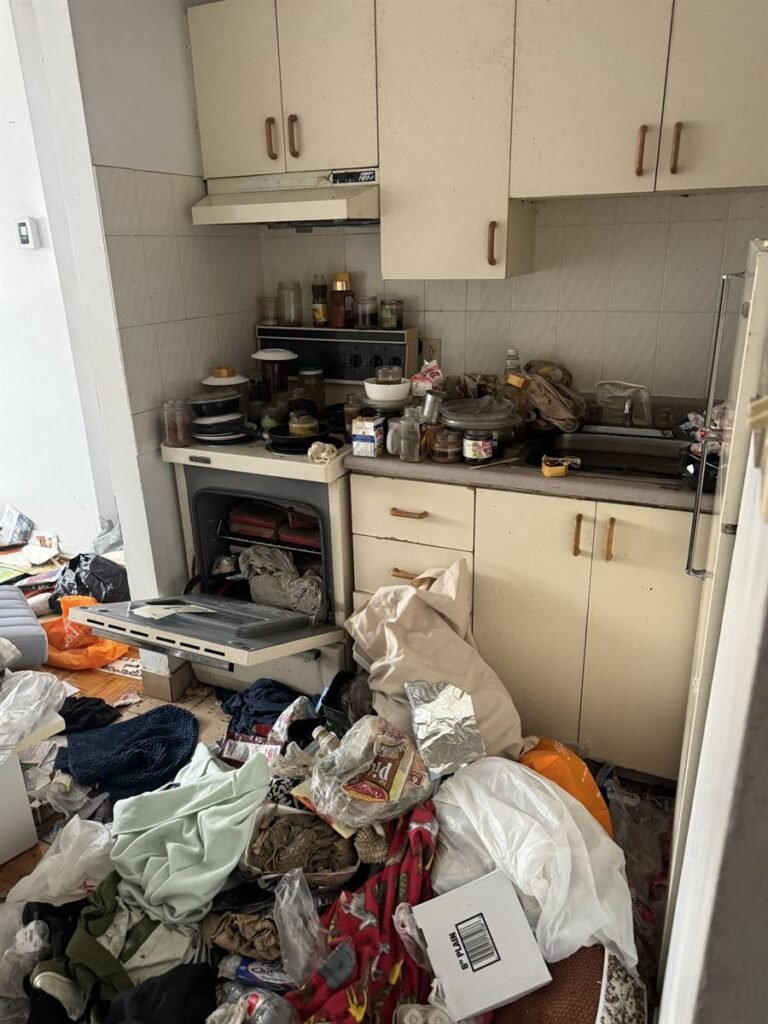 Kitchen piled with bags and clutter in a hoarding situation