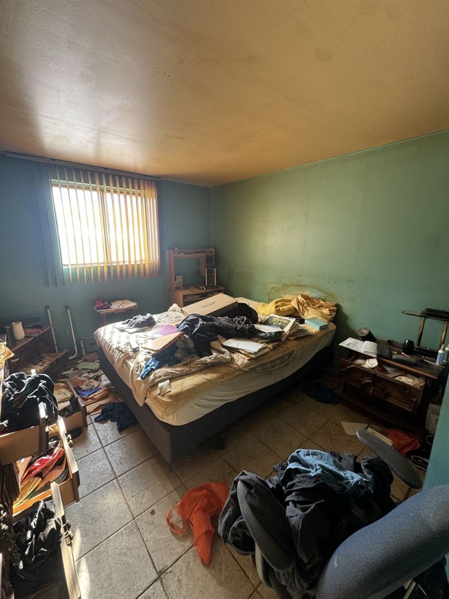 Cluttered bedroom being sorted during a hoarding cleanup