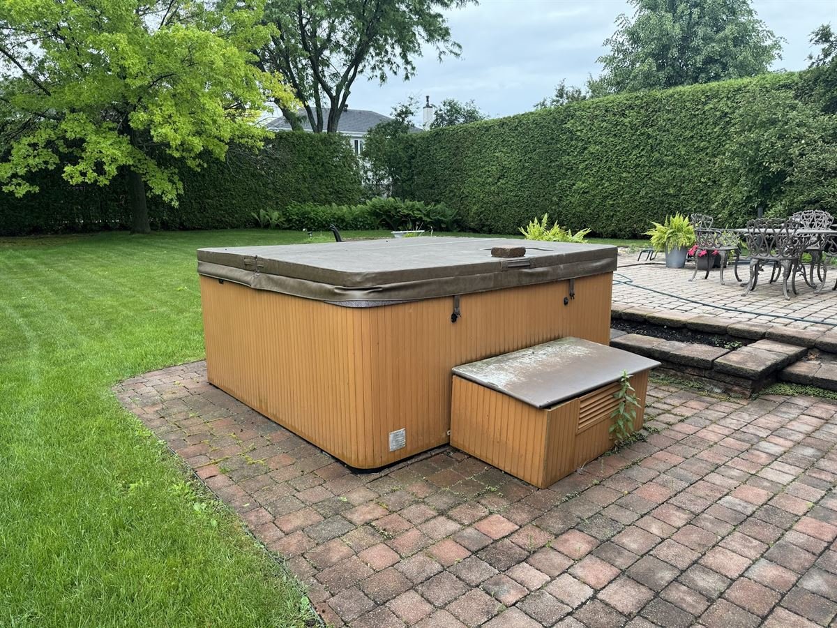 Old hot tub on a backyard patio before removal