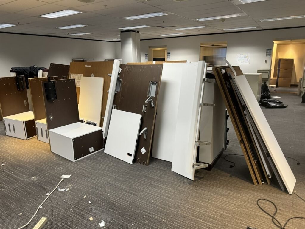 Dismantled office desks and cubicle panels stacked for pickup