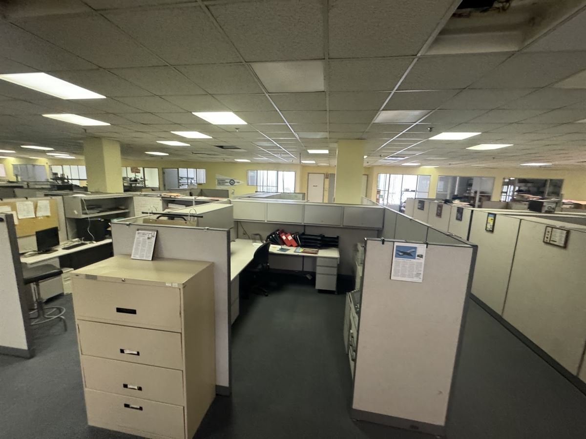 Open-plan office with cubicles and filing cabinets to clear out