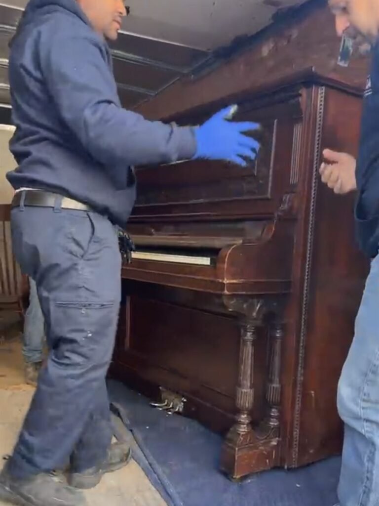 ASAP crew loading an antique upright piano onto the truck