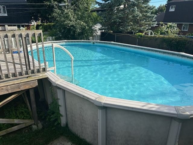 Oval above-ground pool in a backyard before removal