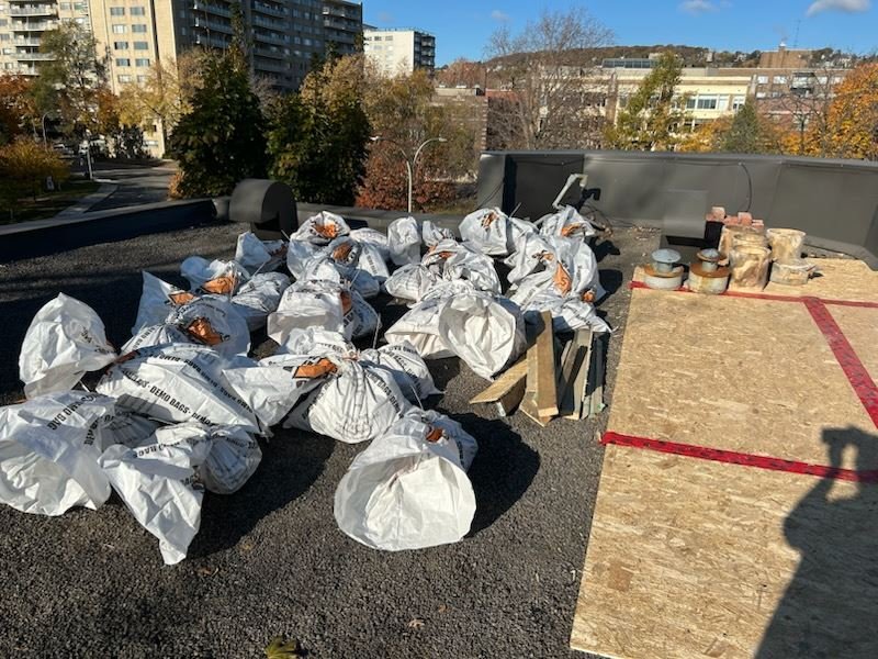 Bags of renovation debris on a rooftop waiting for pickup