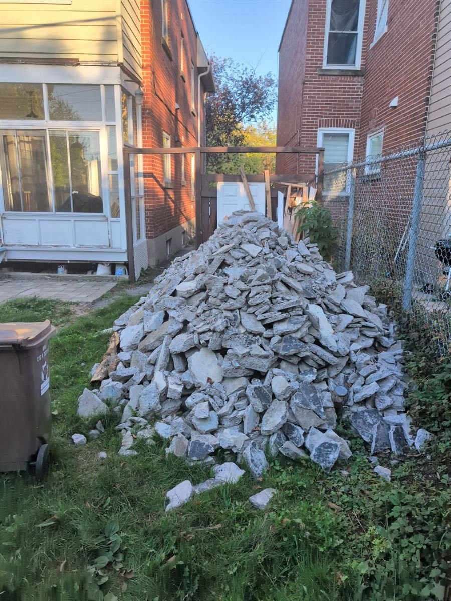 Pile of broken concrete and stone in a side yard
