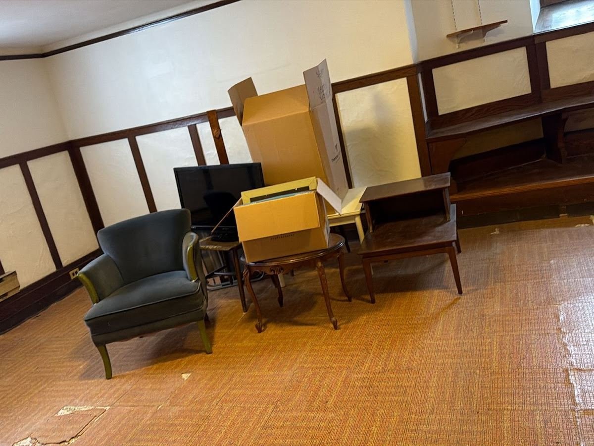 Armchair, tables and boxes left in an emptied room